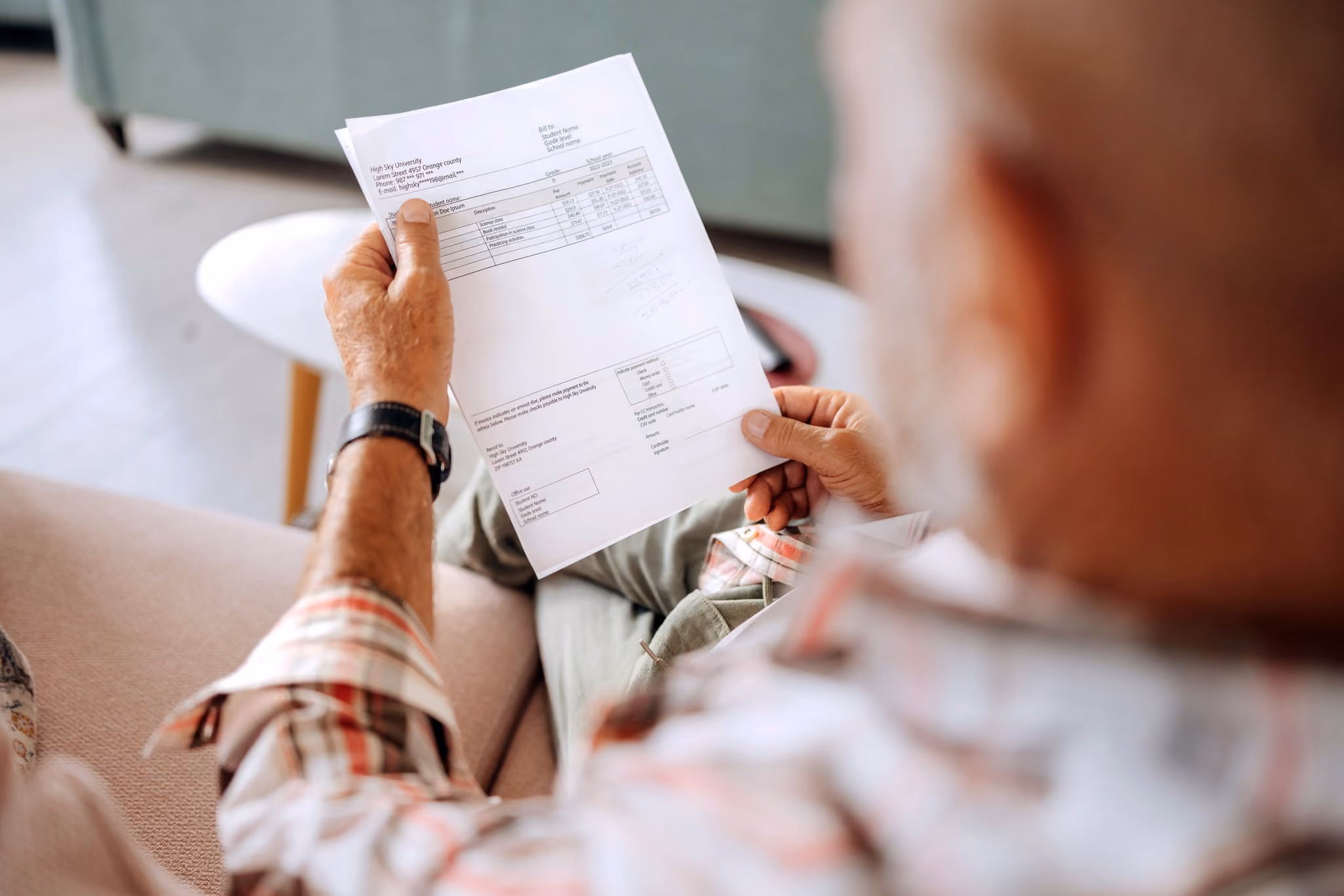 Senior man reviewing bills and paperwork at home