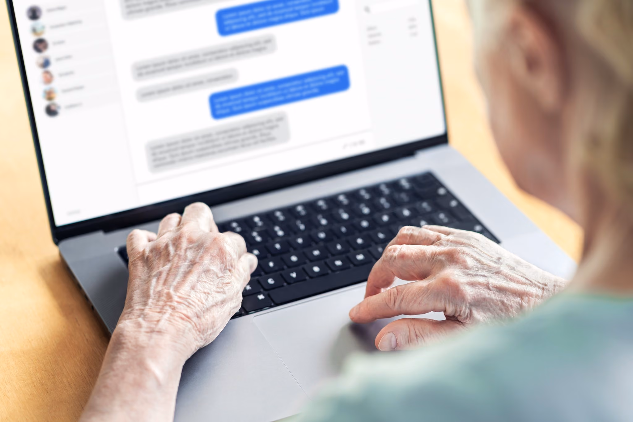 Older woman reading chat messages on a laptop