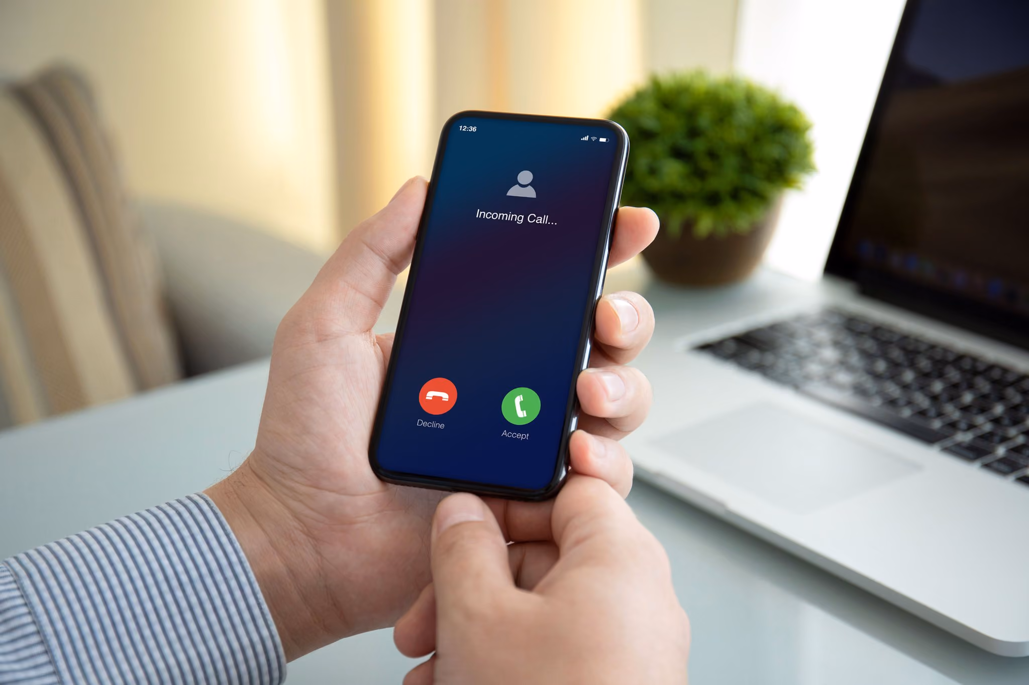 Hands holding a phone showing an incoming call