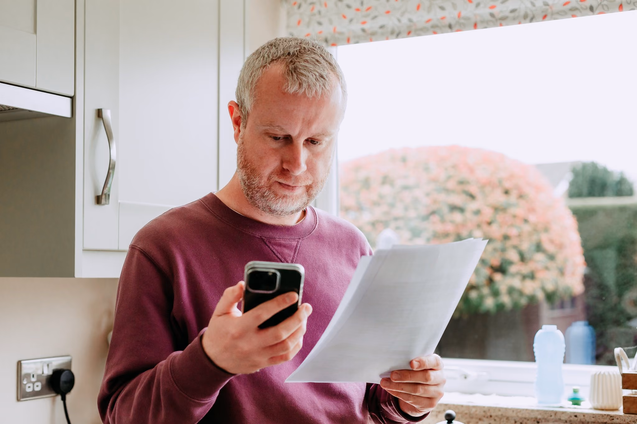 Man checking a bank statement on his phone at home