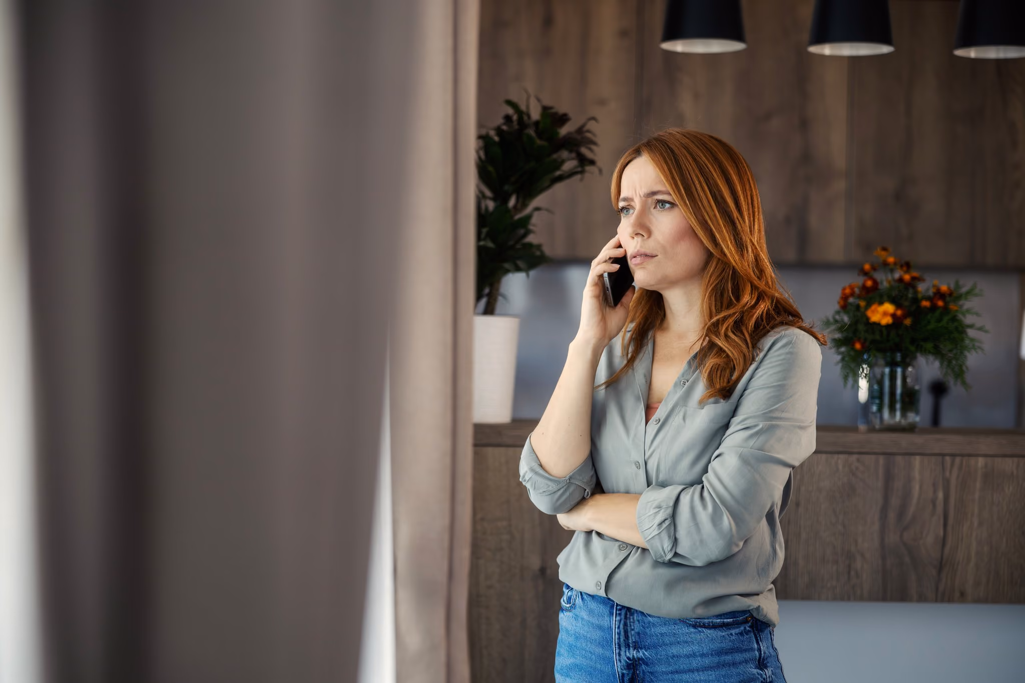 Woman having a serious phone call at home