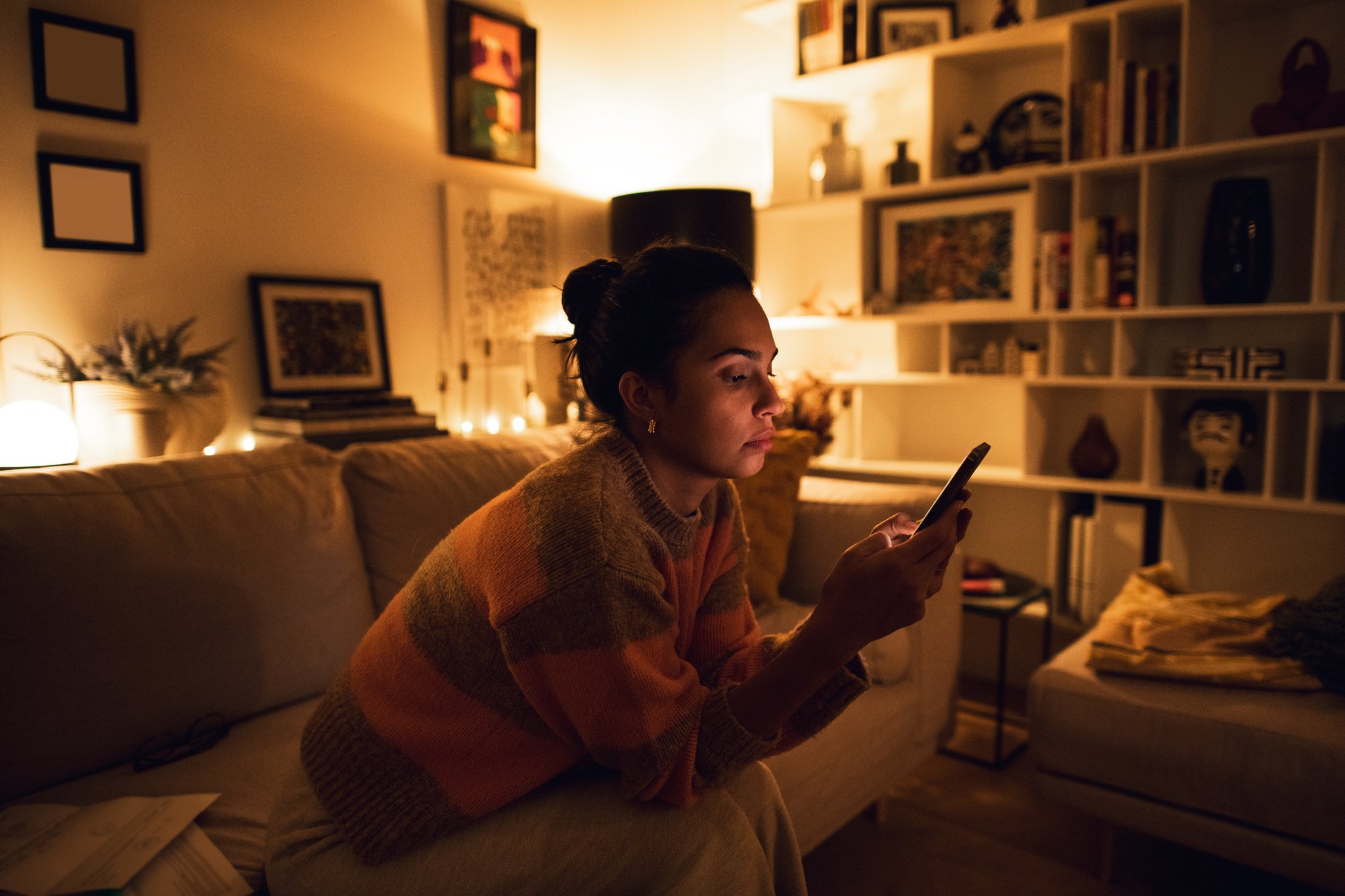 Woman checking her bank account on her phone in the evening