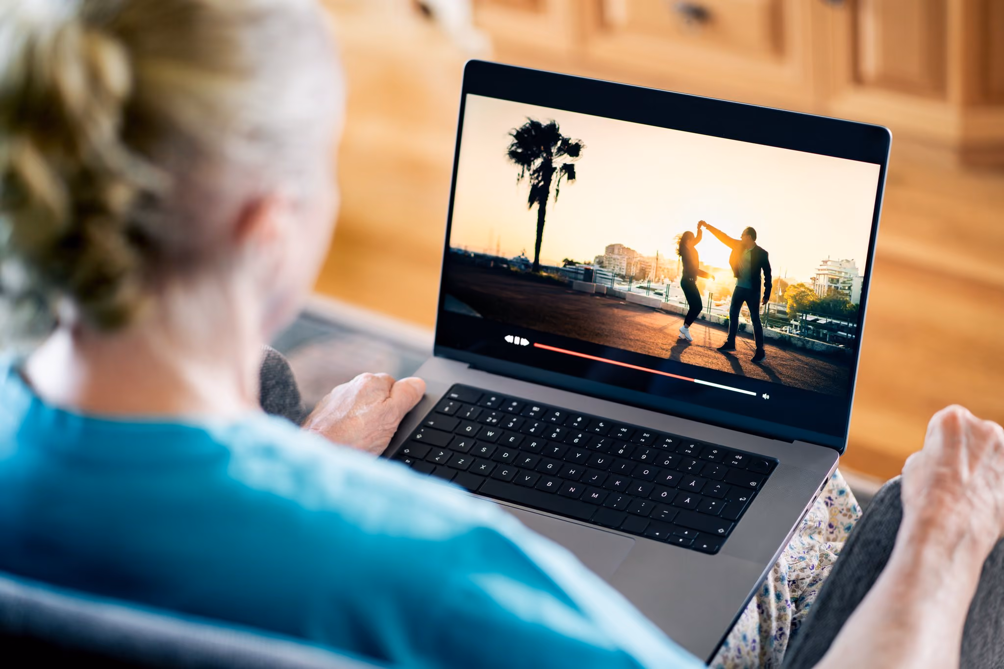 Older woman watching a video on her laptop at home