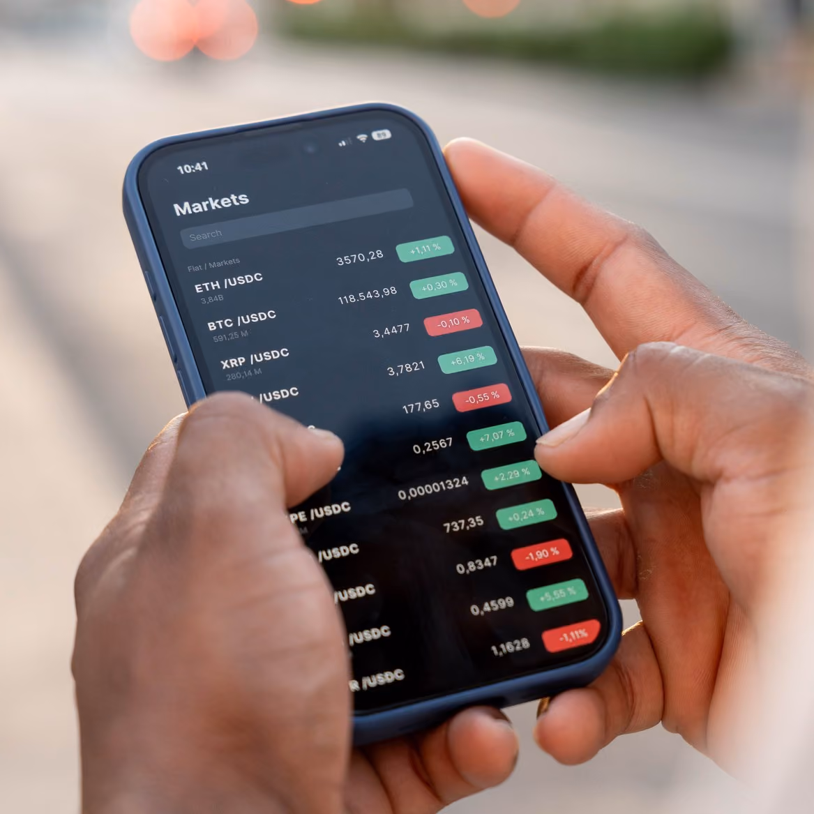 Man checking cryptocurrency prices on a smartphone app