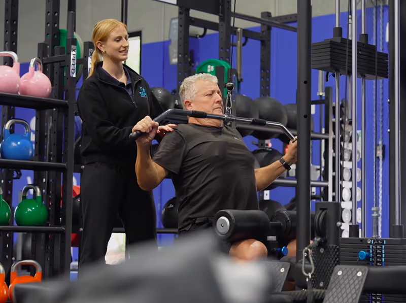 helping client train in the gym