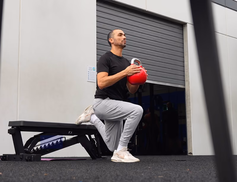 man with kettlebells home gym