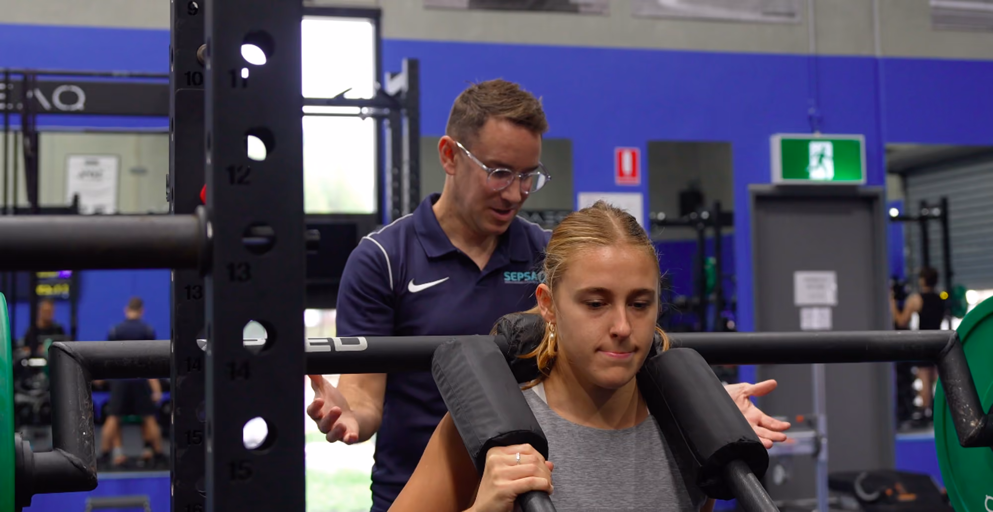 chris helping client with calf machine in sepsa gym