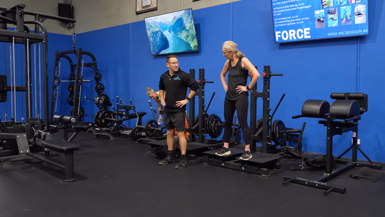 chris showing client how to do step downs in peaq gym
