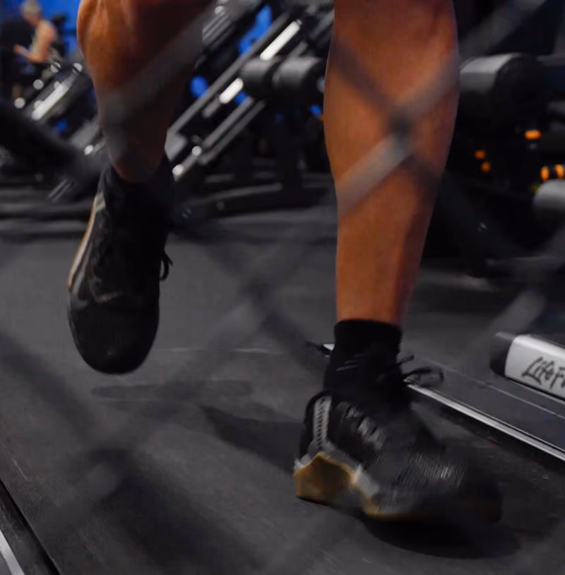 close up of man running on a treadmill in gym