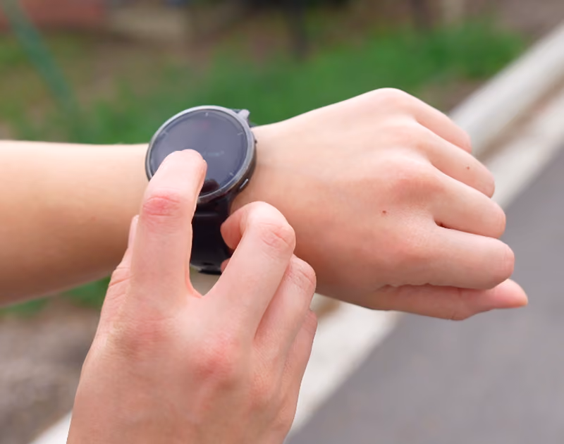 runner tapping on smart watch