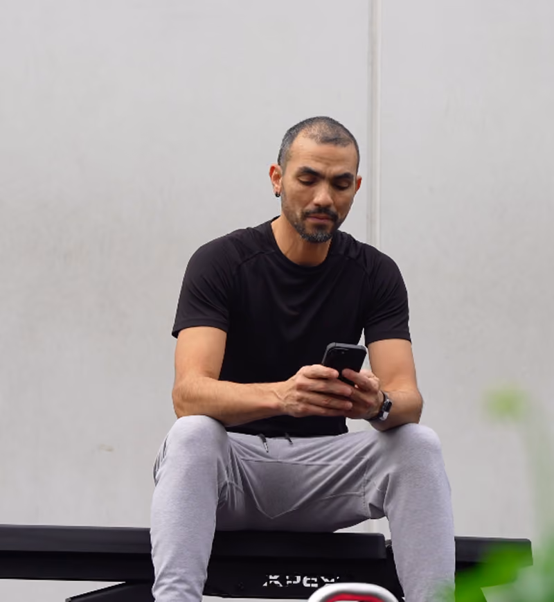 man using phone at home gym