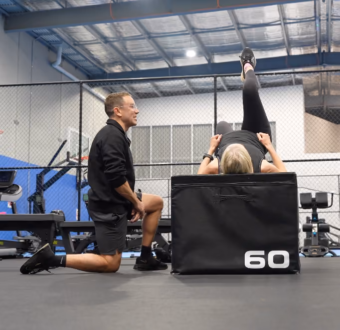 chris helping client with rehab using jump box