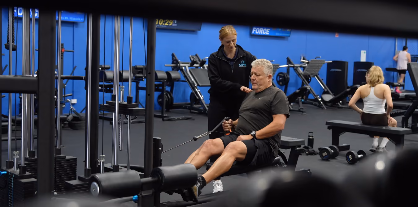 Chantel helping client do pull downs in gym