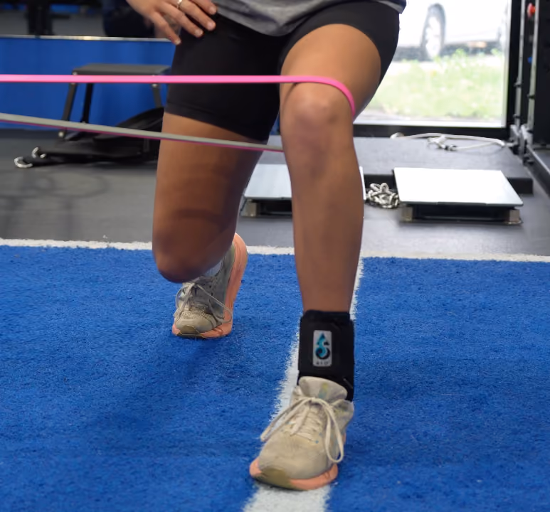 runner doing lunges with pink band around knee