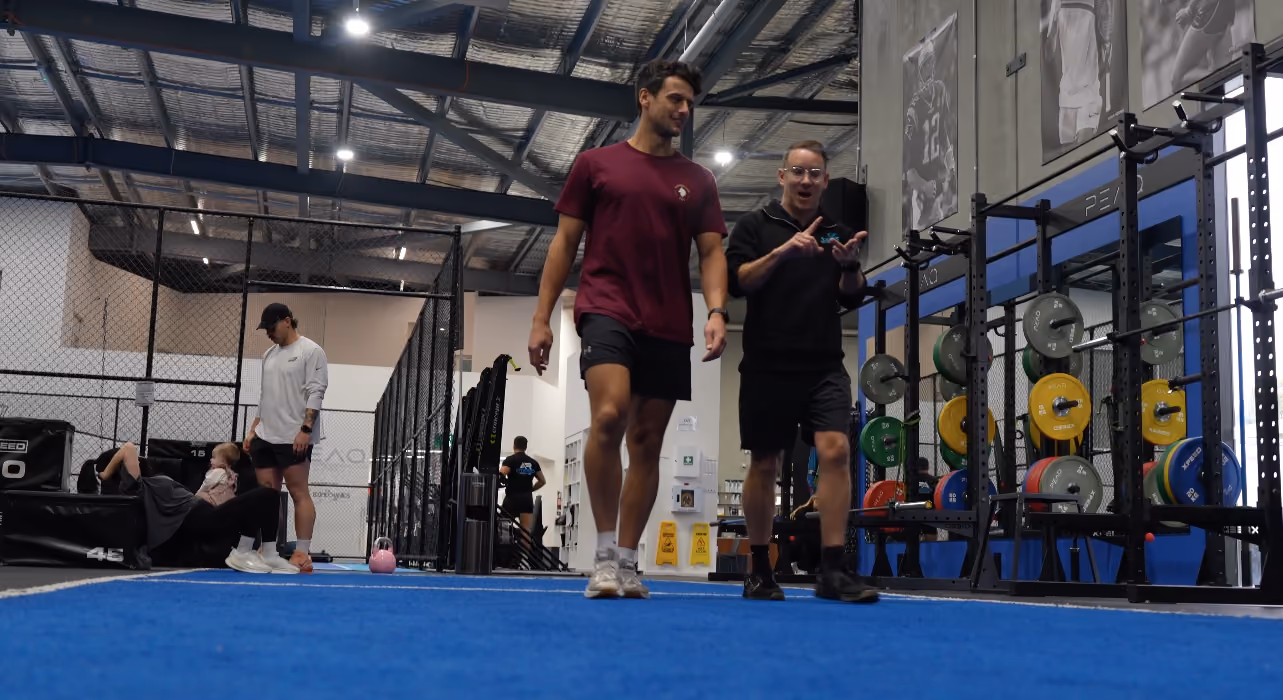chris helping teenage male with gym program