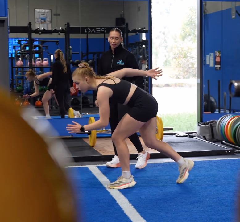 teen athlete in gym practising hurdles