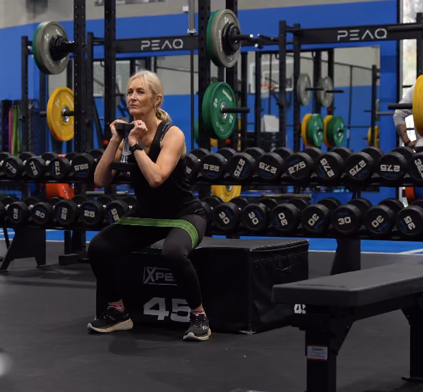 lady doing squats with band in the gym