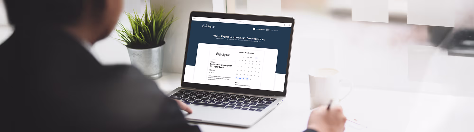 Person sitzt am Schreibtisch und bucht über die Website von PG Digital GmbH ein kostenloses Erstgespräch online per Laptop.