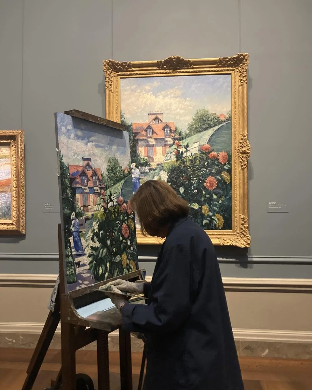 An artist studying a painting in a museum
