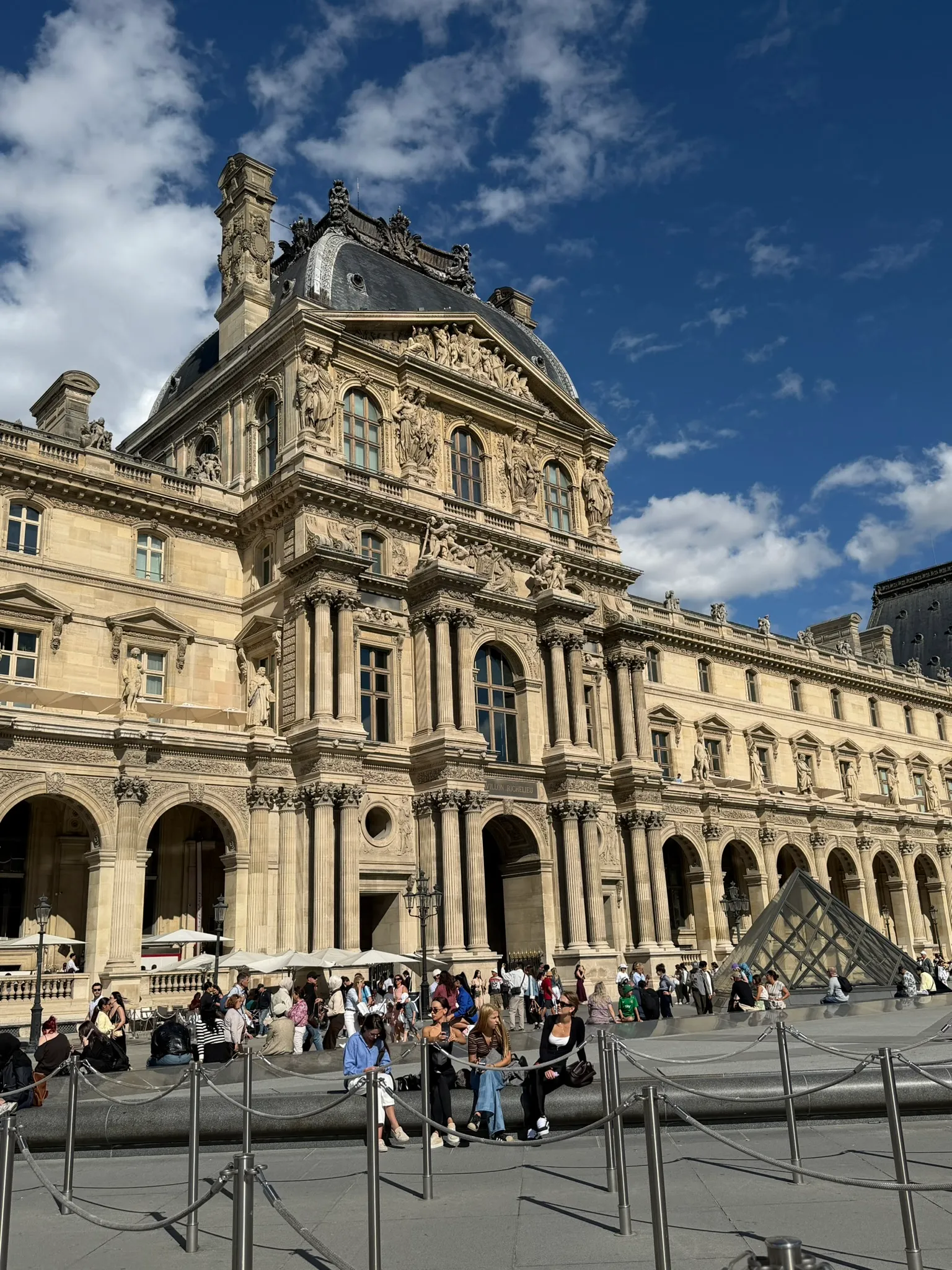 Louvre Museum façade and sculpted architectural details overlooking the Cour Napoléon in Paris