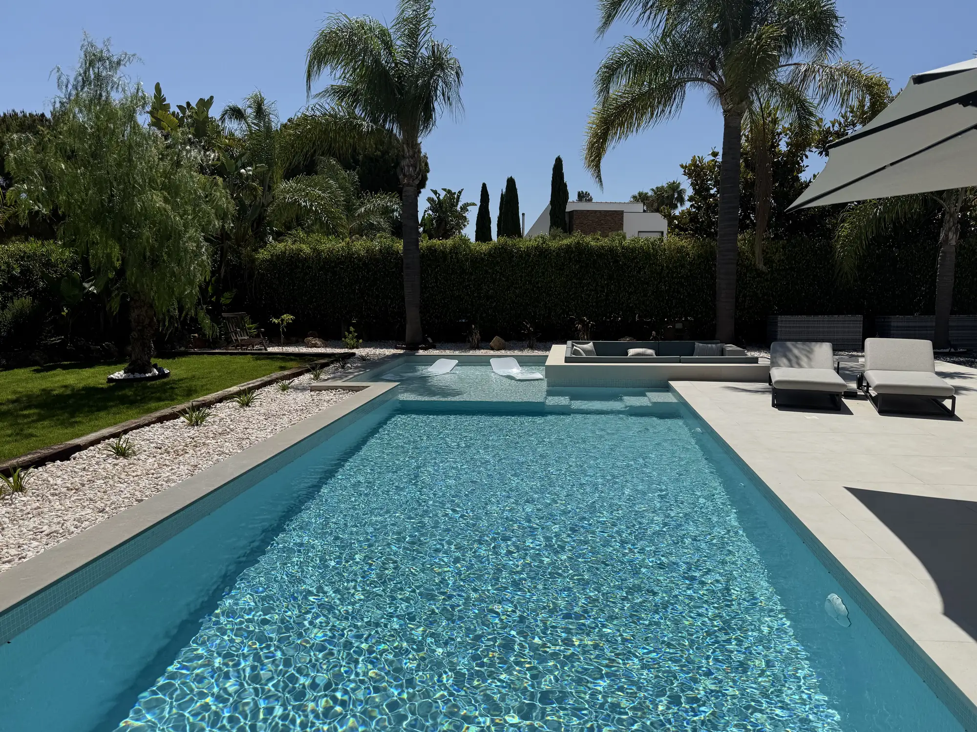 Piscina exterior com palmeiras em moradia no Algarve