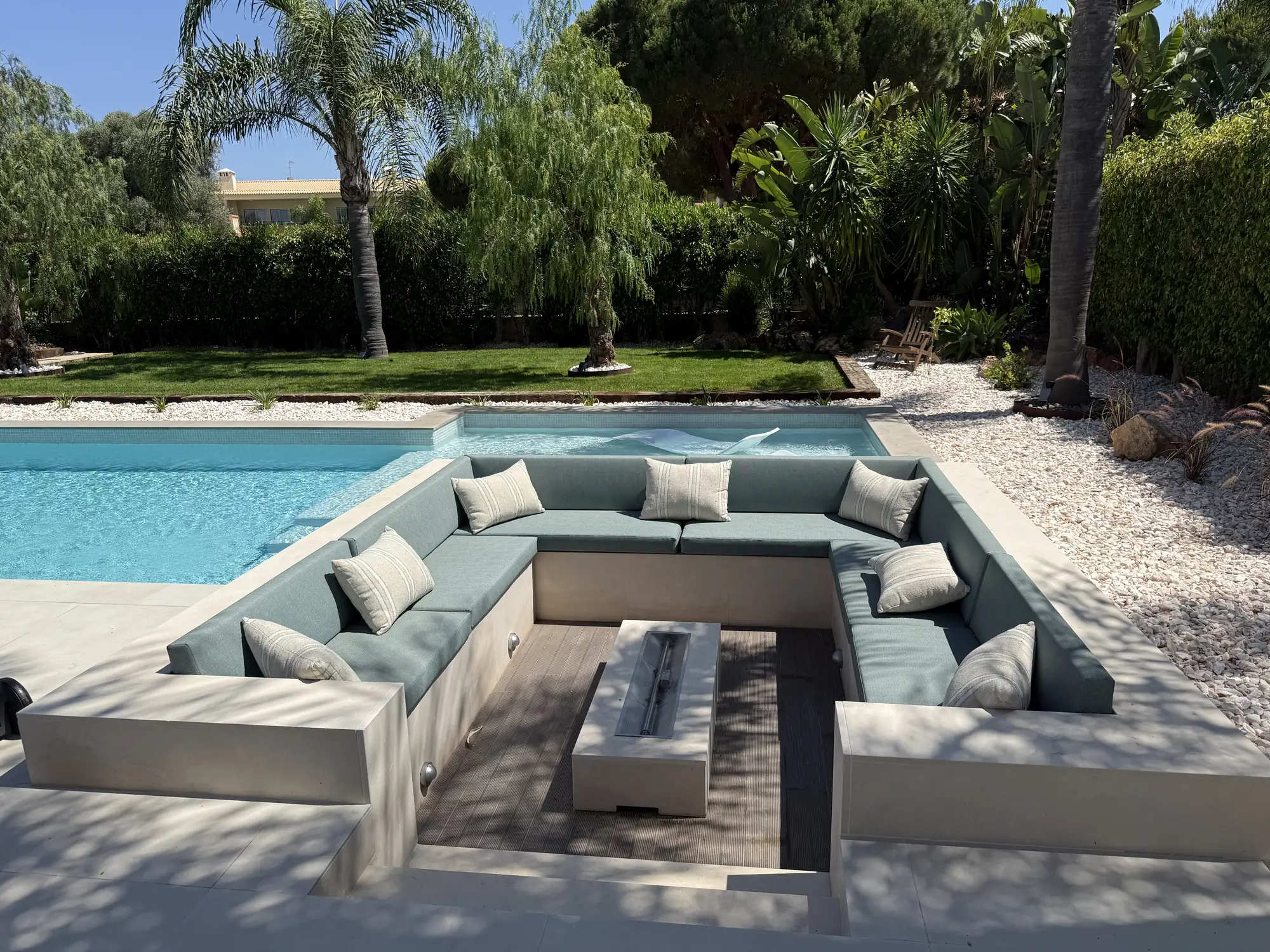 Zona de estar exterior com lareira junto à piscina
