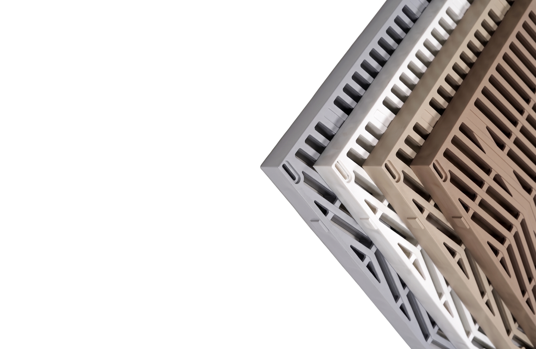 Stack of plastic floor drain covers in gray, white, and brown shades on black background.