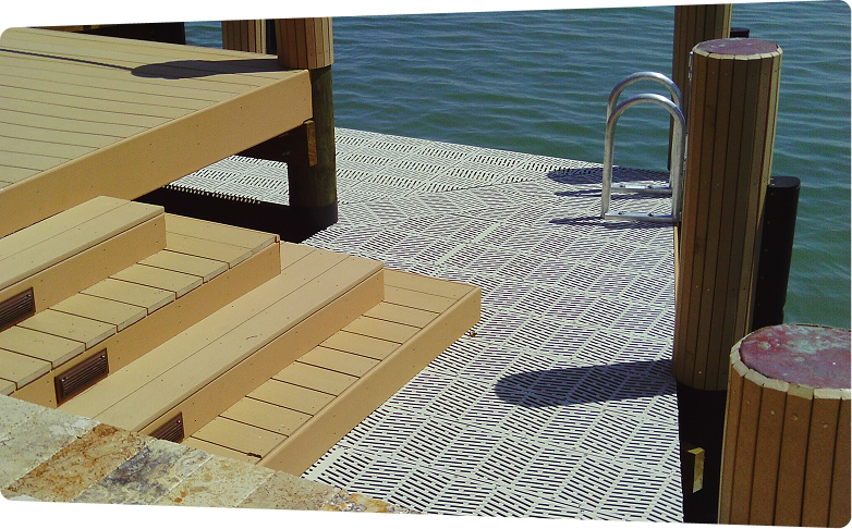 Wooden dock steps leading down to water with textured platform and metal ladder.