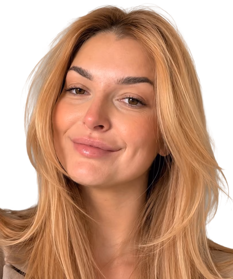 Woman with long blonde hair smiling slightly with a neutral background.