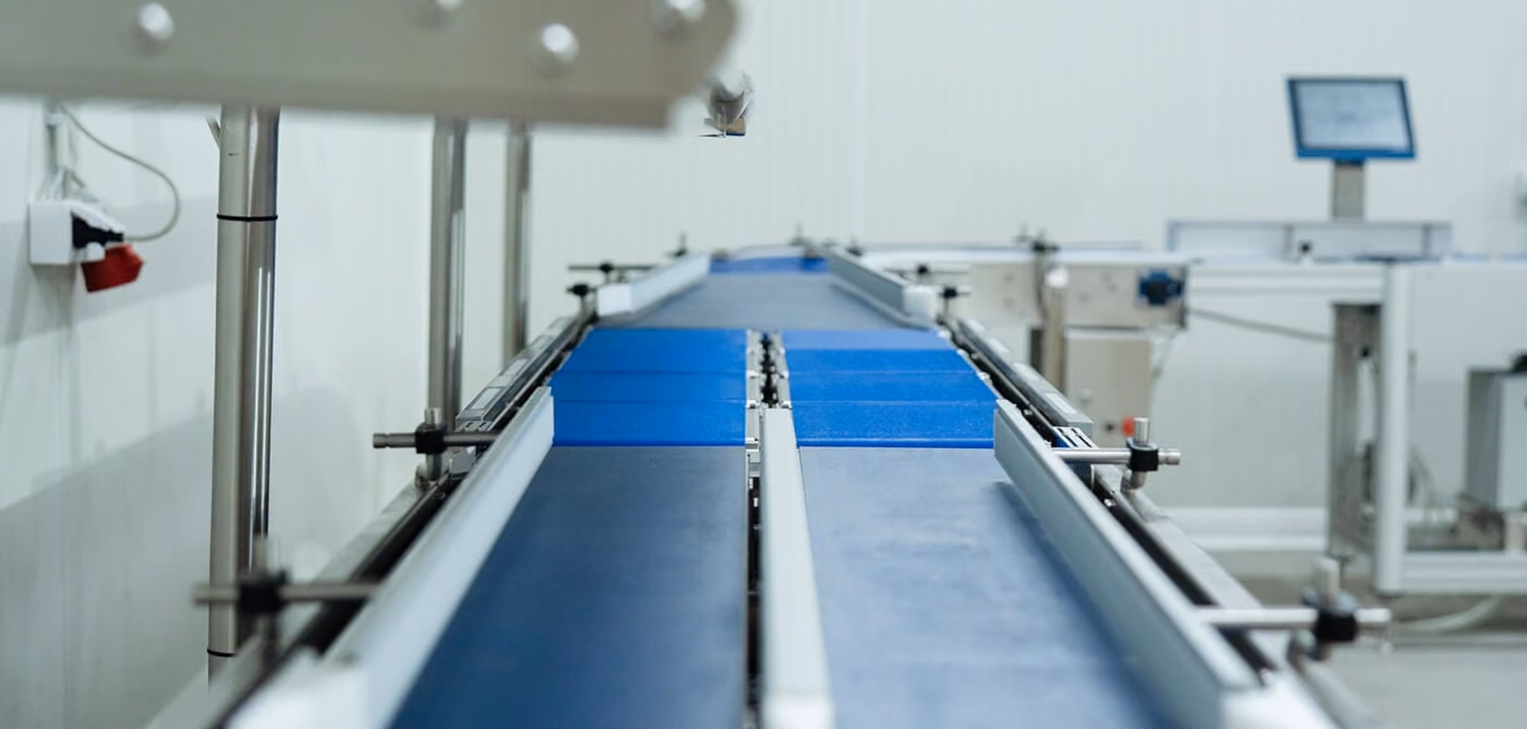 Empty conveyor belt system in a clean industrial or manufacturing facility.