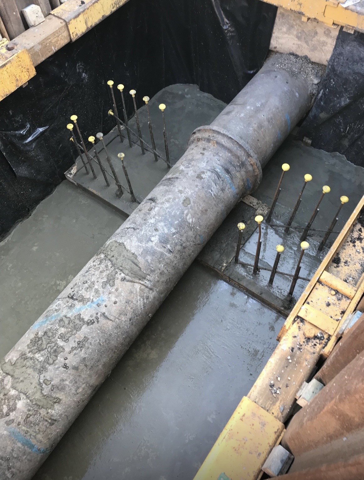 Concrete surround and reinforcement around a rebuilt pipe