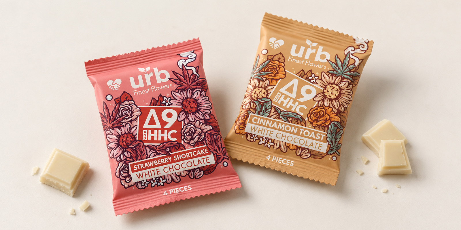 Two URB cannabis-infused white chocolate pouches in strawberry shortcake and cinnamon toast flavours, photographed with pieces of white chocolate on an off-white background.