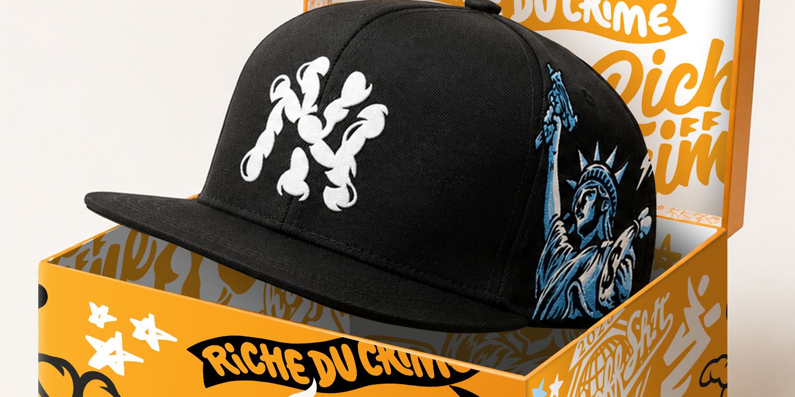 Black Rich Off Crime cap presented inside a custom orange display box with illustrated interior and exterior packaging artwork.