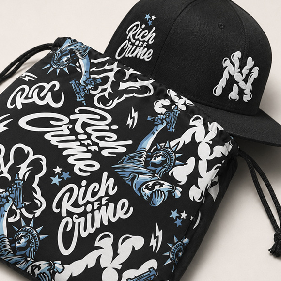Black Rich Off Crime cap displayed with a matching illustrated drawstring dust bag featuring blue, white and black artwork.