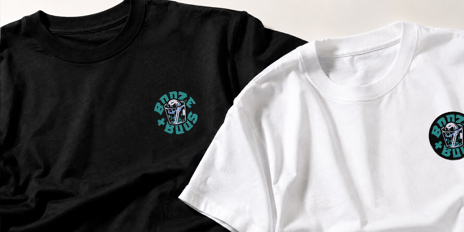 Black and white Booze + Boos T-shirts featuring the circular skull-and-drink logo as a small chest print.