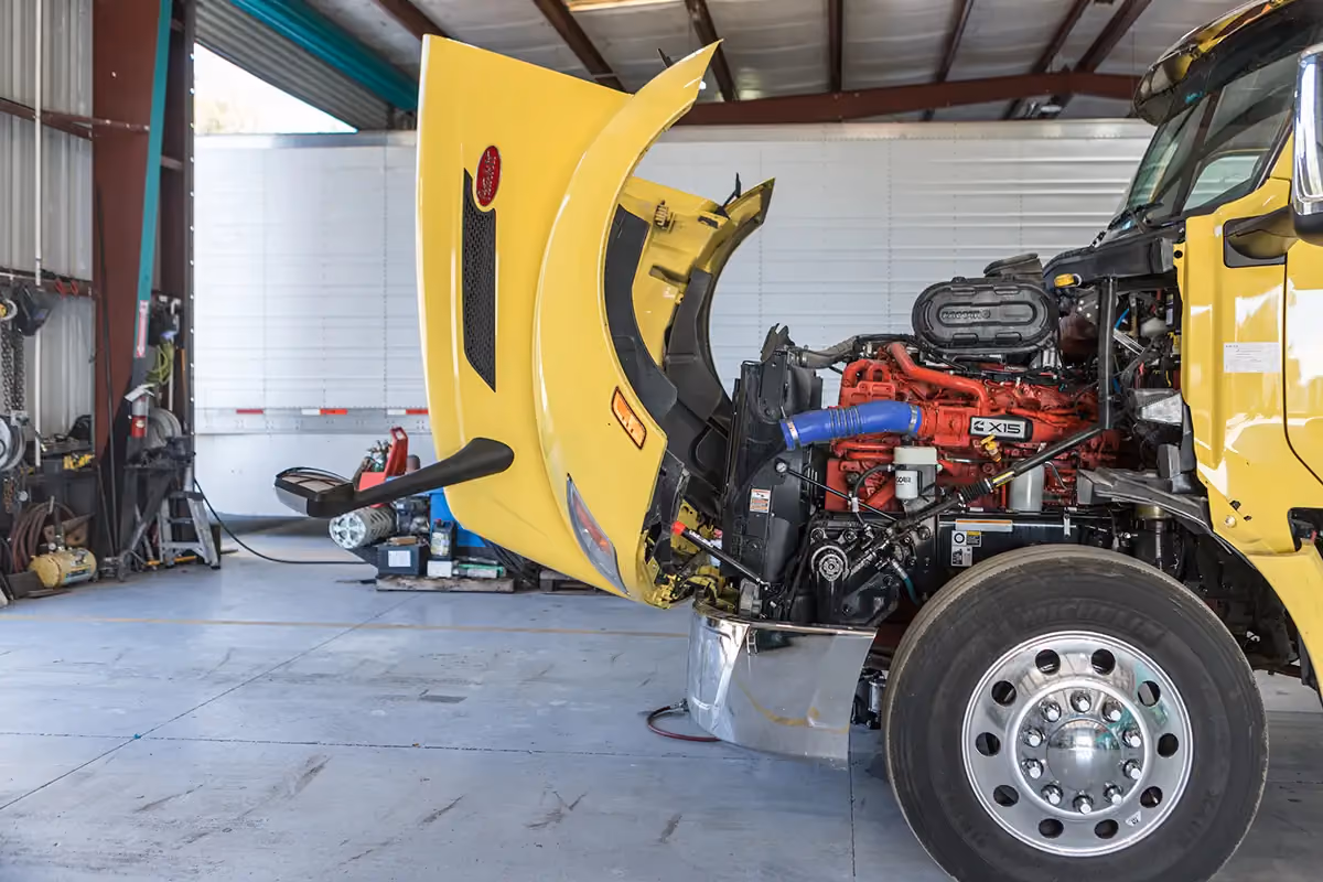 Diesel mechanic performing preventive maintenance services on semi-truck