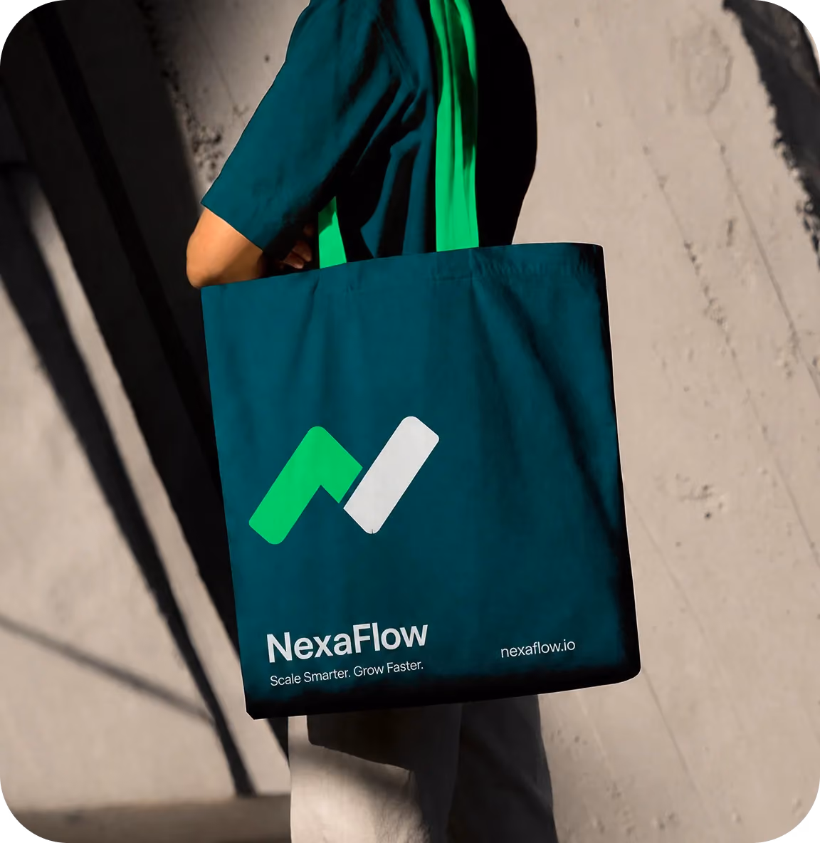 Person carrying a dark tote bag with the NexaFlow logo and tagline in green and white text.