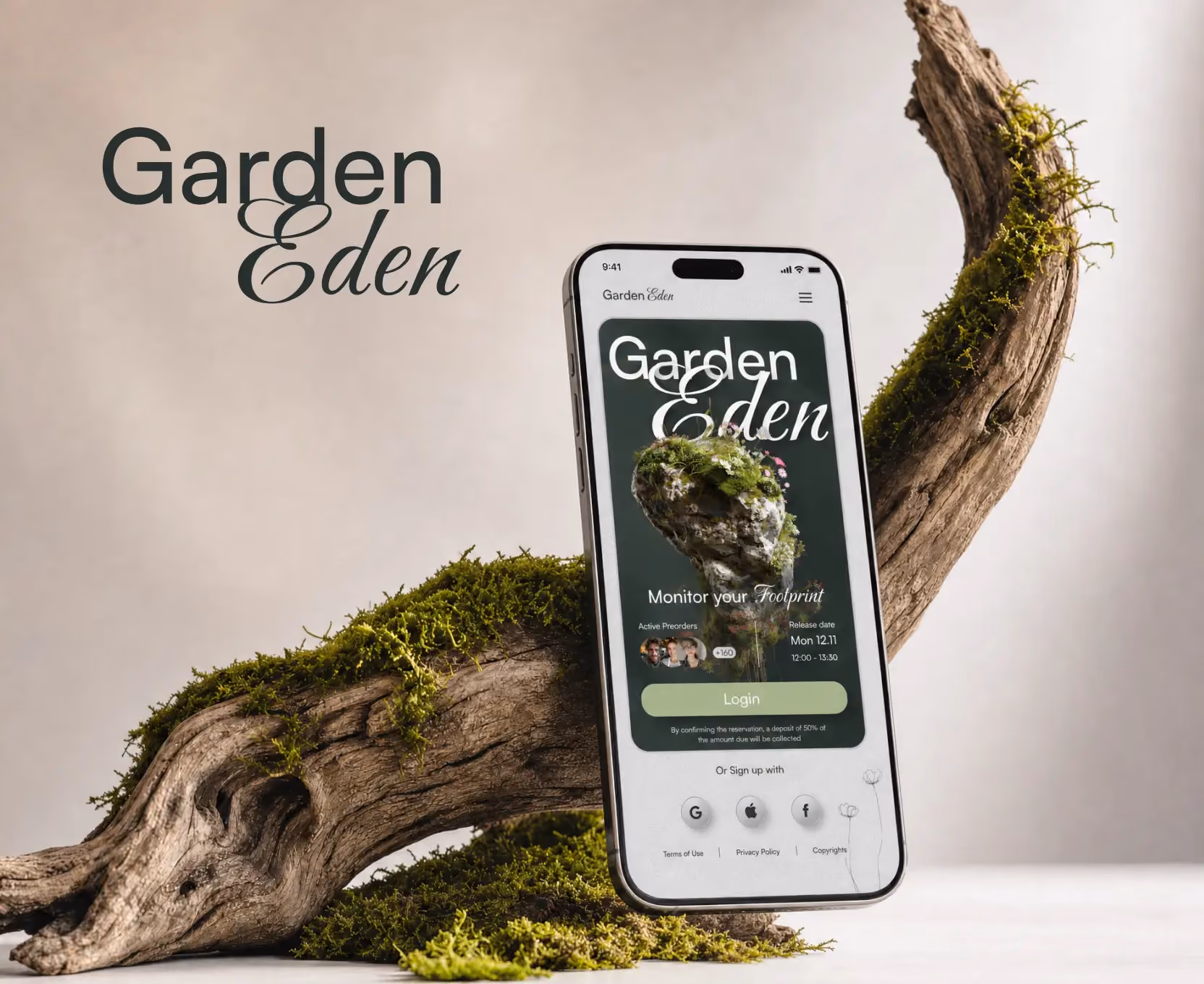 Smartphone showing Garden Eden app with mossy wood branch and moss decor in background.