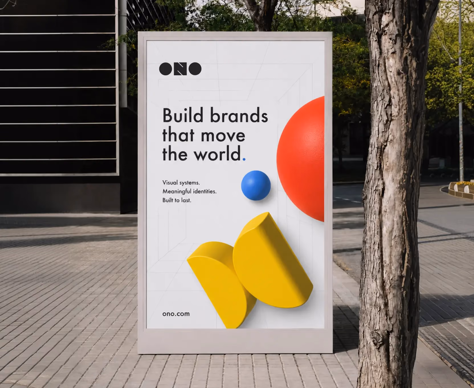 Outdoor advertisement board with text 'Build brands that move the world' and colorful geometric shapes.