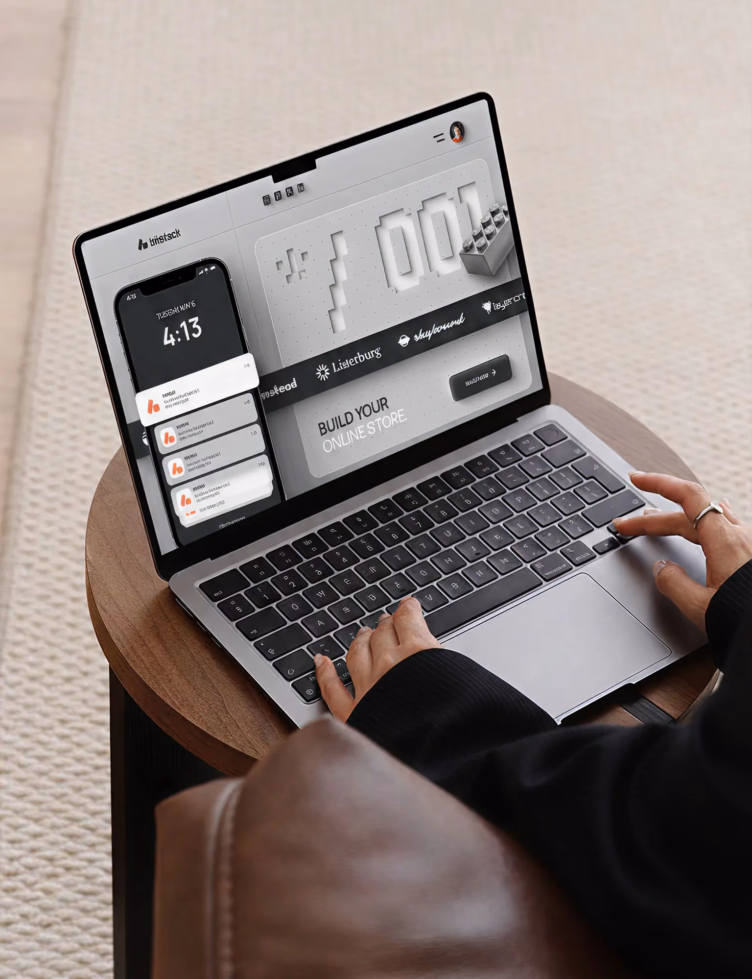 Person typing on laptop showing app interface with smartphone image and text 'Build Your Online Store.'