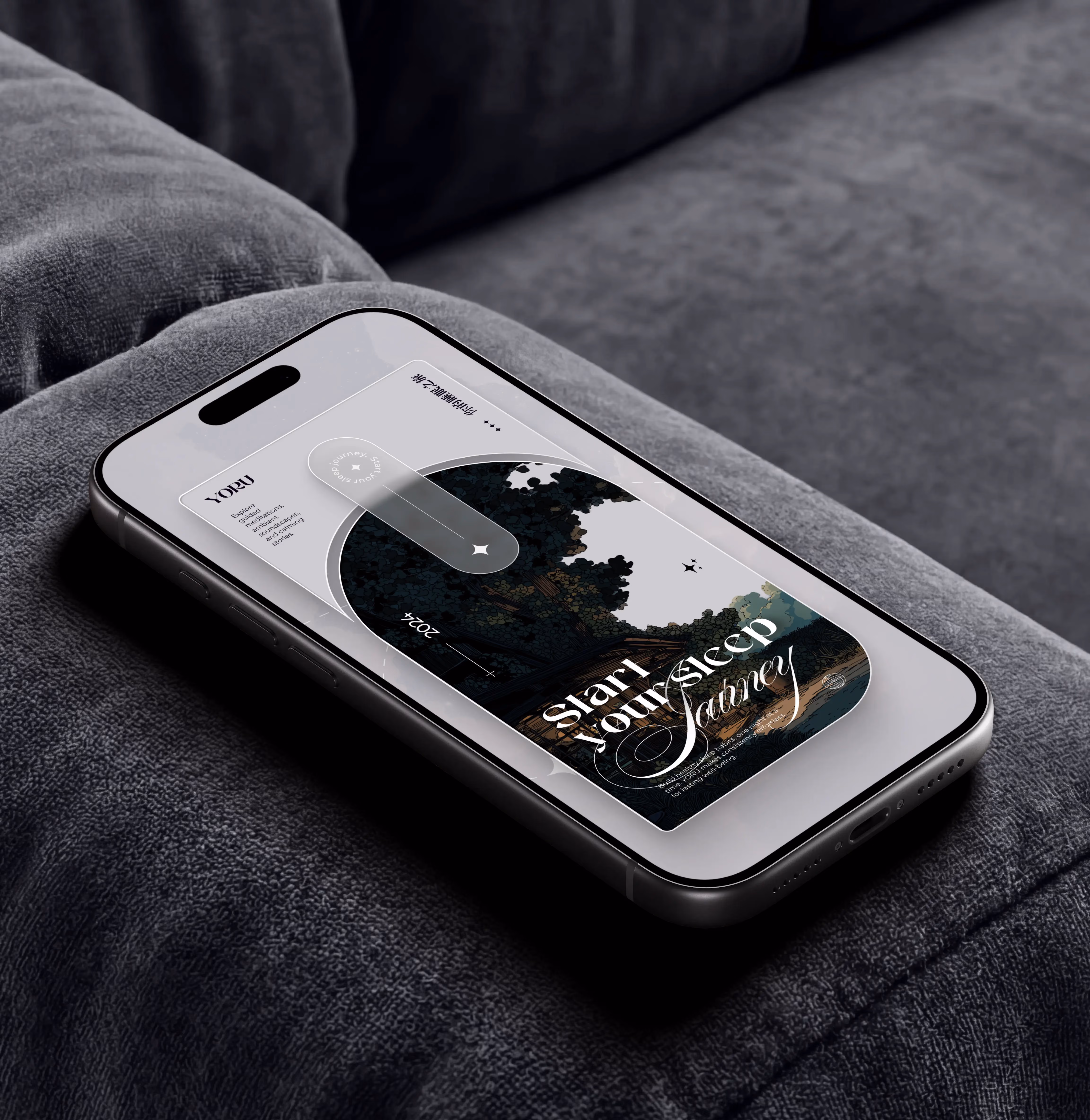 Smartphone on gray fabric showing a sleep journey app with a night scene and text 'Start Your Sleep Journey'.