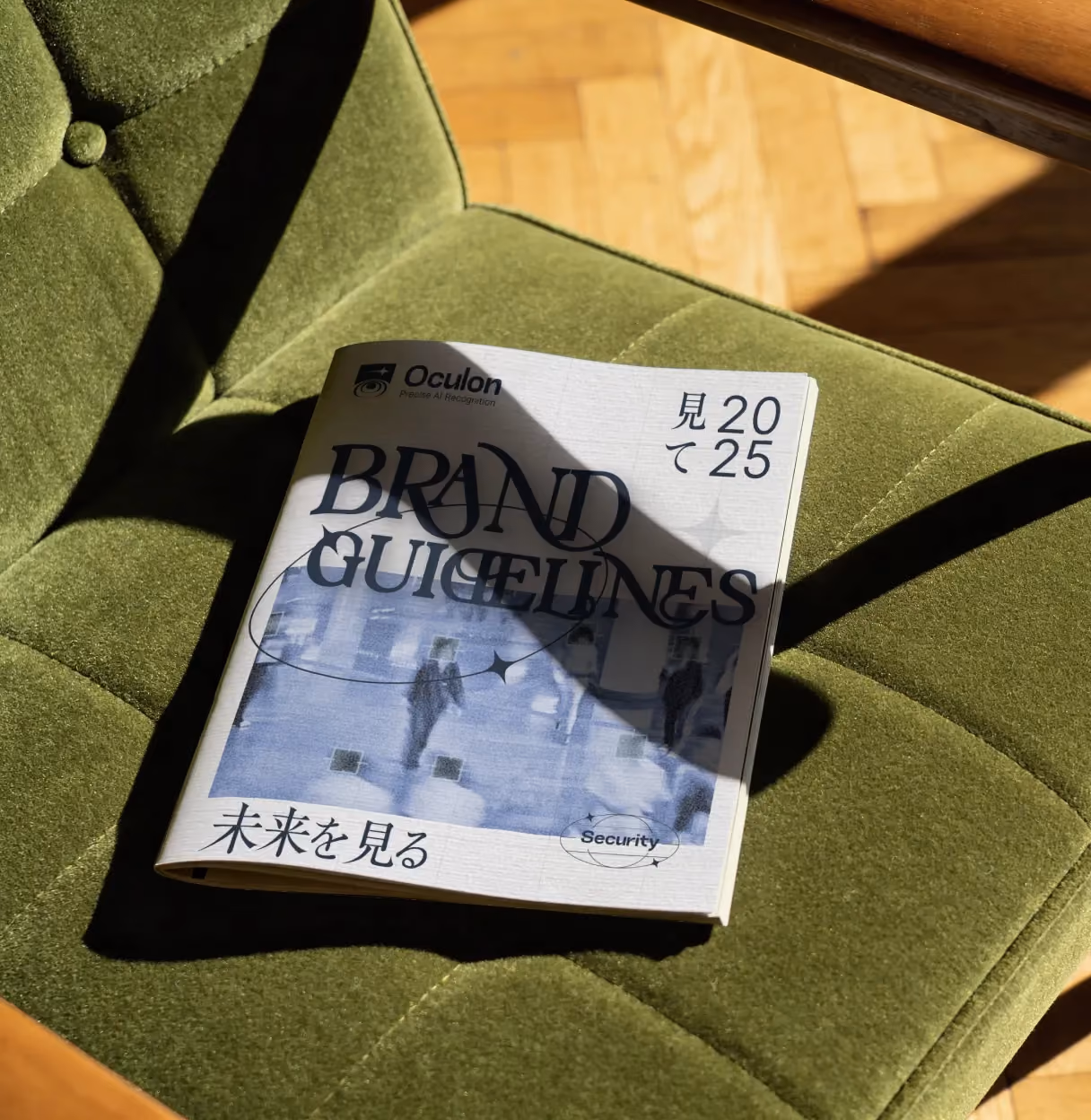 Brand guidelines booklet on green cushioned chair with sunlight and shadow across it.