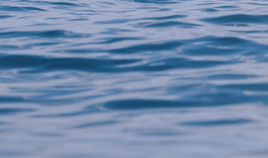 Close-up view of gentle ripples on a calm blue water surface.