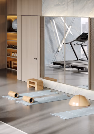 Modern gym room with exercise mats, foam rollers, a step platform, a balance dome, and treadmill behind glass.