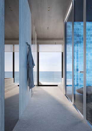 Modern salt room with glass walls and view of ocean through a large window.