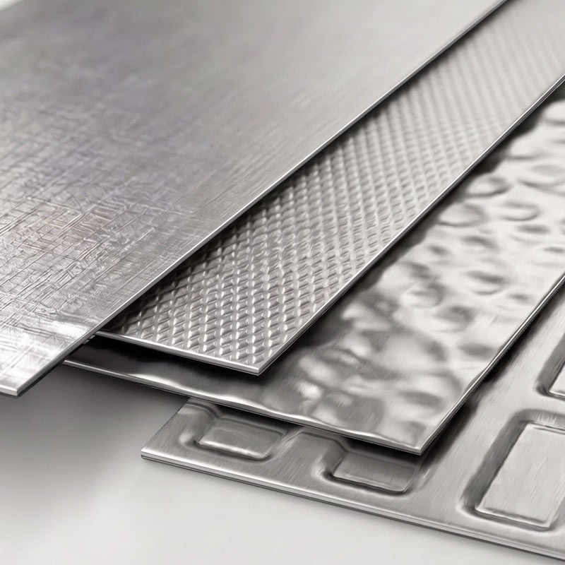 Stack of aluminum sheets with different embossed surface textures including crosshatch, diamond pattern, hammered, and geometric designs.
