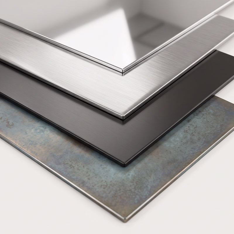 Stack of four rectangular aluminum panels with different finishes: reflective silver, brushed silver, matte black, and textured blue-gray.