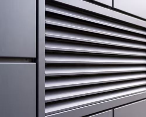 Close-up of a modern building facade with horizontal metal louver panels designed for ventilation.