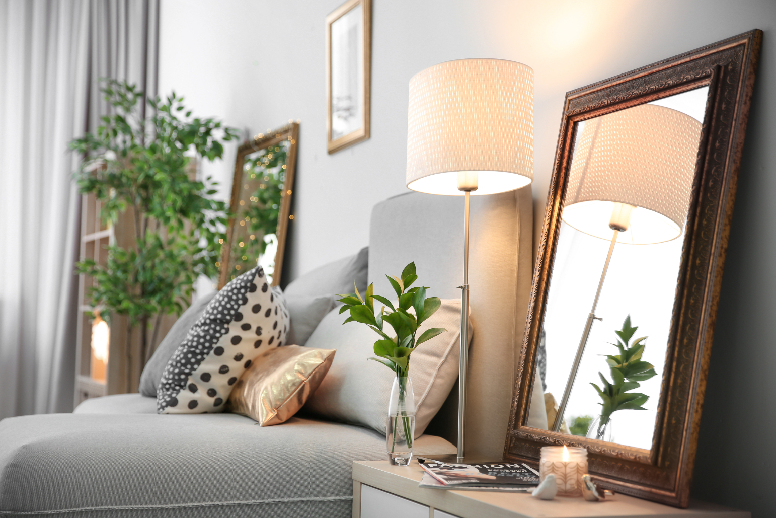 Bedroom with be, plants, and mirror stock image