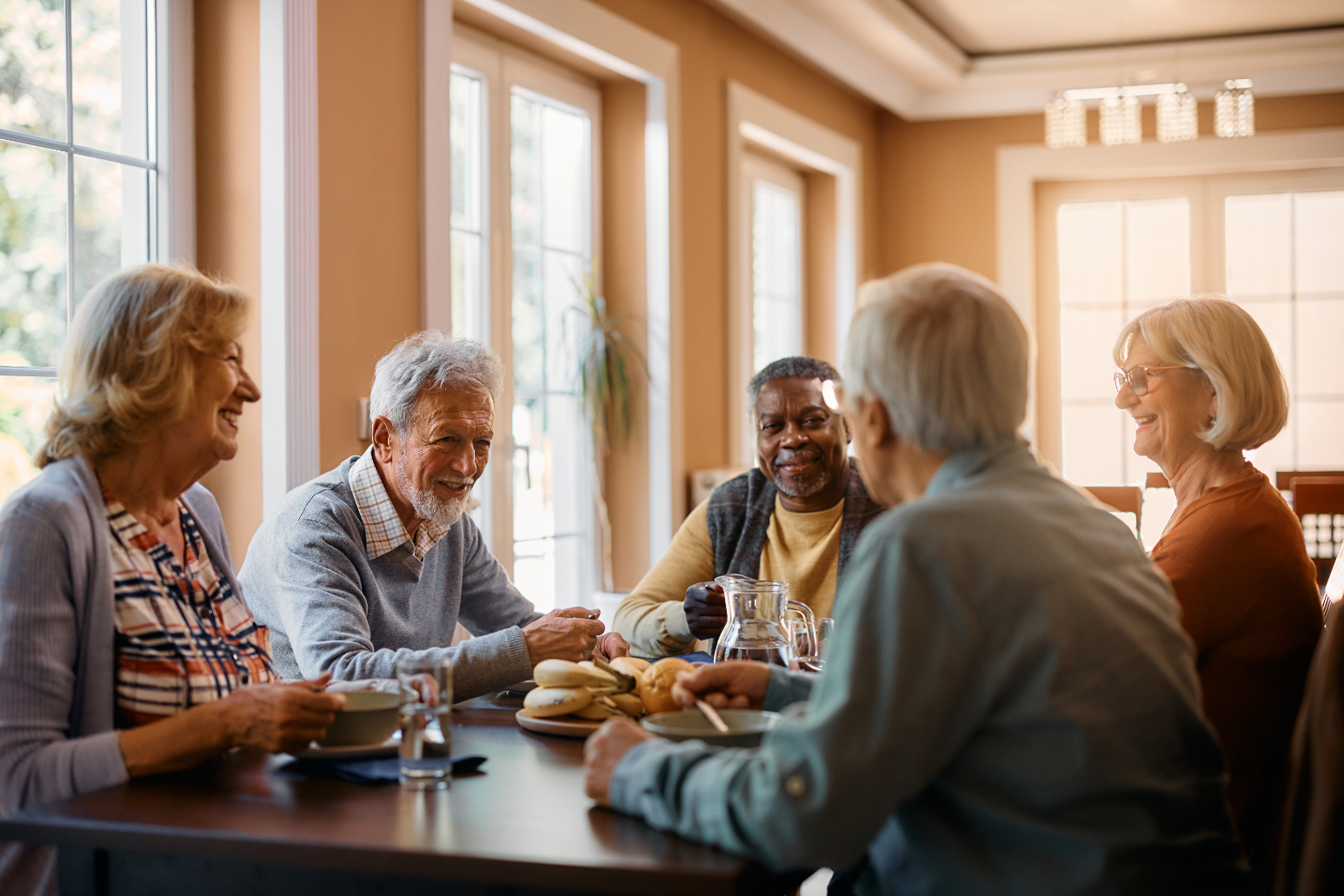 Seniors gather around table stock image